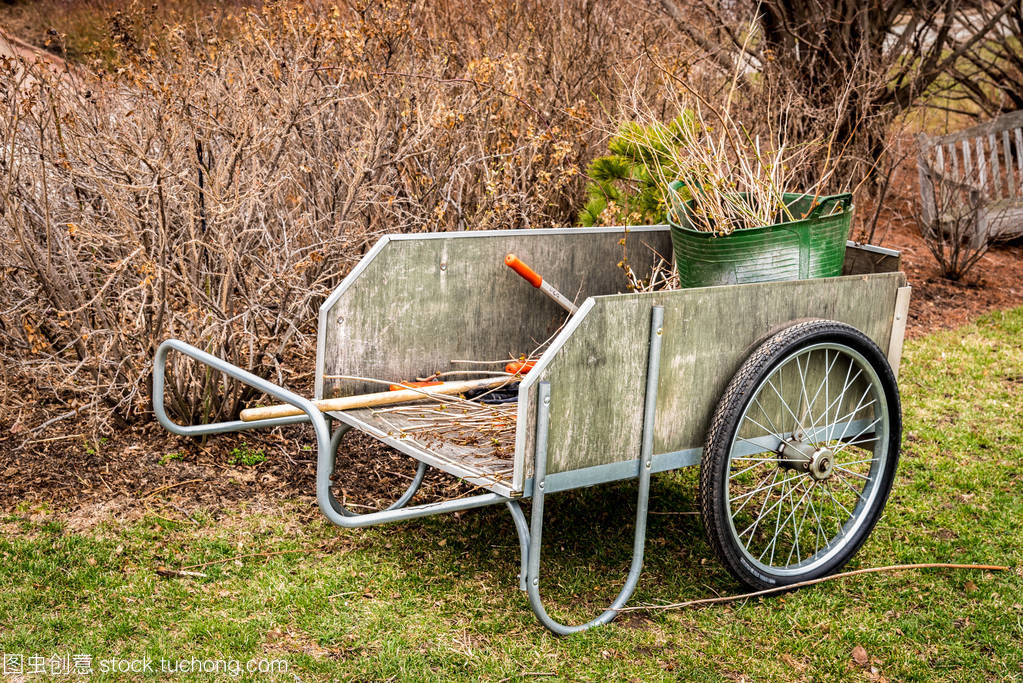工具與修剪的樹(shù)枝的木制花園車(chē)收集后早春美化清理